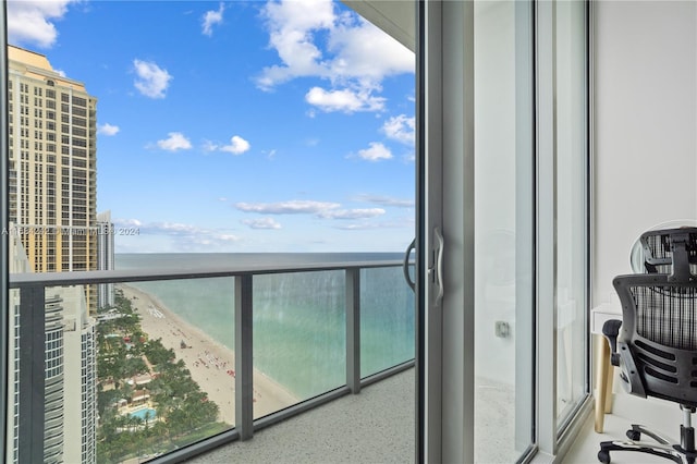 balcony with a water view and a view of the beach