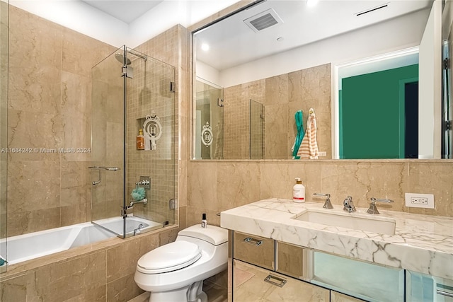 full bathroom with tile patterned floors, decorative backsplash, toilet, sink, and bath / shower combo with glass door