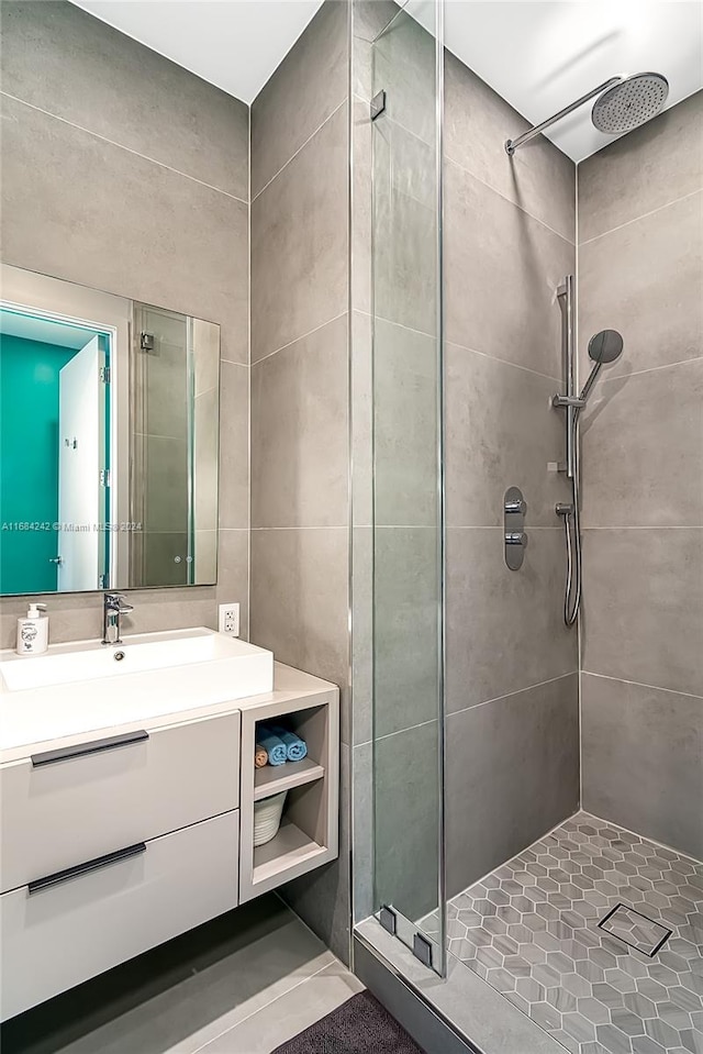 bathroom featuring a tile shower and vanity