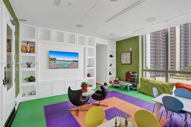 game room with built in shelves and carpet floors