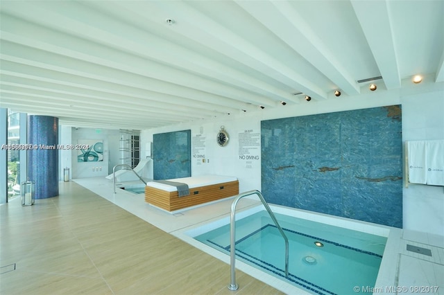 view of swimming pool with an indoor hot tub