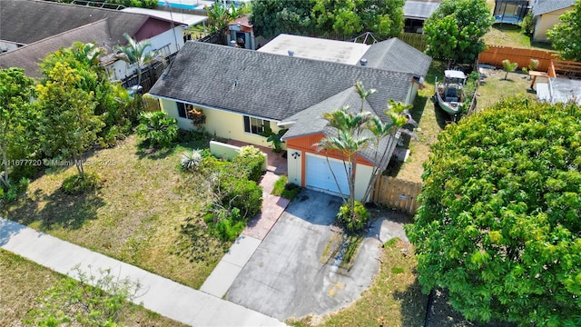 view of front of home with a front yard, fence, a garage, and driveway
