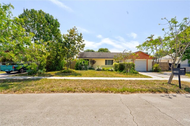 view of front of home with a front yard and a garage