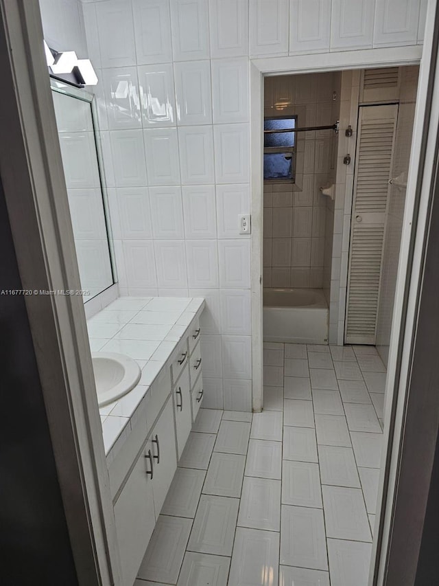 bathroom featuring vanity, tile patterned floors, and tile walls