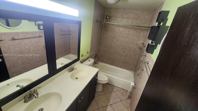 full bathroom featuring tile patterned flooring, tiled shower / bath, vanity, and toilet