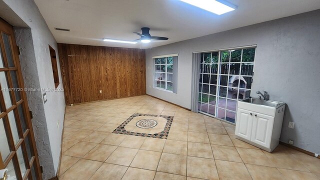 tiled empty room featuring sink and ceiling fan