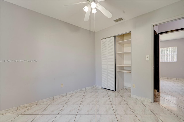 unfurnished bedroom featuring a closet, visible vents, a ceiling fan, and light tile patterned flooring