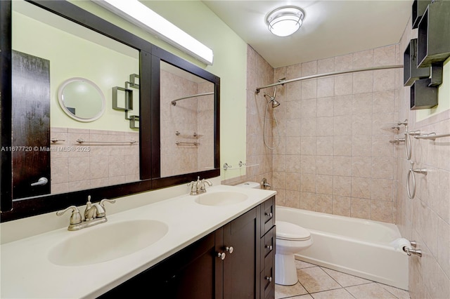 bathroom with tile patterned floors, toilet, washtub / shower combination, and a sink