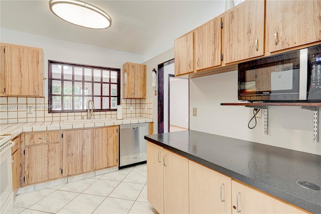 kitchen featuring light tile patterned flooring, light brown cabinetry, decorative backsplash, a sink, and stainless steel dishwasher