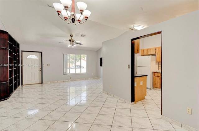 interior space featuring lofted ceiling, light tile patterned floors, ceiling fan with notable chandelier, and visible vents