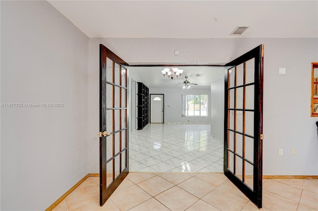hallway with tile patterned floors, a notable chandelier, baseboards, and visible vents