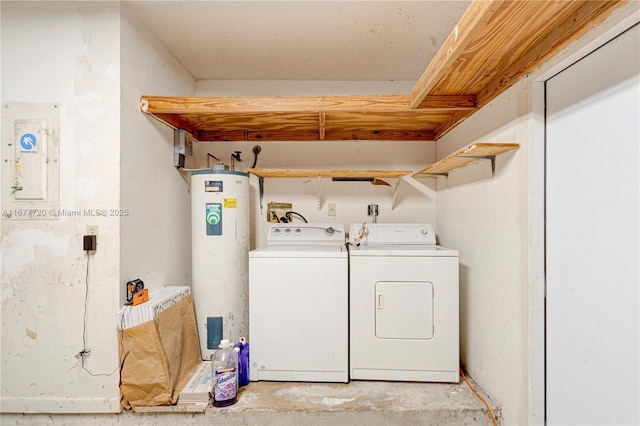 clothes washing area featuring water heater, laundry area, and washer and clothes dryer