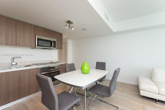 dining space with light hardwood / wood-style floors and sink