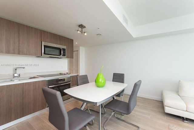 1600 SW 1st Ave Unit 1104, Miami, FL 33129 - kitchen with stainless steel appliances, modern cabinets, wood finish floors, brown cabinetry, and light countertops