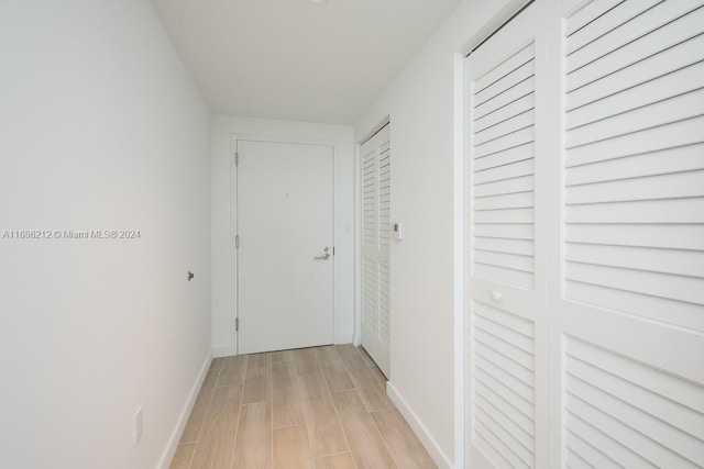 hallway with light hardwood / wood-style floors