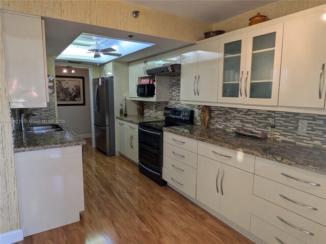 kitchen featuring stainless steel fridge, black range with electric cooktop, sink, wood-type flooring, and white cabinetry