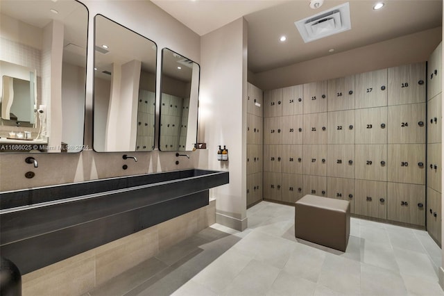 bathroom featuring vanity, backsplash, tile walls, and tile patterned flooring