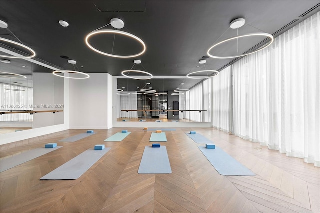 exercise room featuring parquet flooring