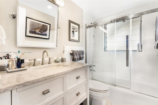 full bathroom with vanity, enclosed tub / shower combo, and toilet