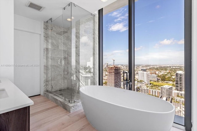 bathroom with vanity, hardwood / wood-style floors, and independent shower and bath