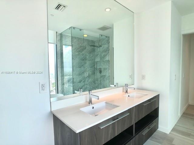 bathroom with vanity, an enclosed shower, and hardwood / wood-style flooring