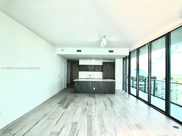 kitchen featuring a wealth of natural light, expansive windows, and light wood-type flooring