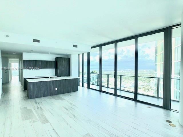 interior space featuring light wood-type flooring and a wall of windows