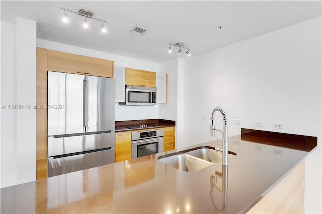 kitchen with sink, light brown cabinets, and stainless steel appliances