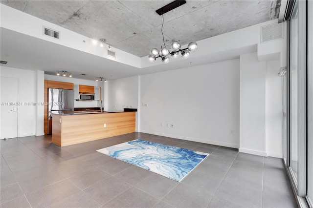 kitchen featuring an inviting chandelier, kitchen peninsula, stainless steel appliances, and a breakfast bar area