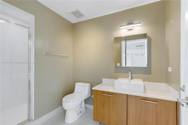 bathroom with vanity, tile patterned floors, toilet, and walk in shower