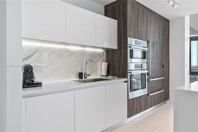 851 NE 1st Ave Unit 3302, Miami, FL 33132 - kitchen with modern cabinets, a sink, tasteful backsplash, white cabinetry, and light countertops