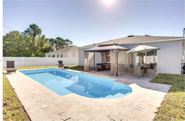 2613 SW Harem Cir, Port St Lucie, FL 34953 - view of pool featuring a gazebo, a patio area, and a fenced backyard