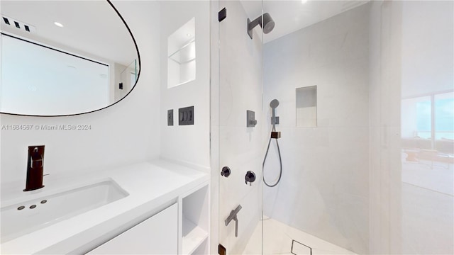 bathroom featuring plenty of natural light, vanity, and tiled shower