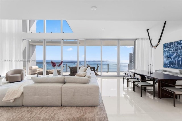 living room featuring a healthy amount of sunlight, a water view, and floor to ceiling windows