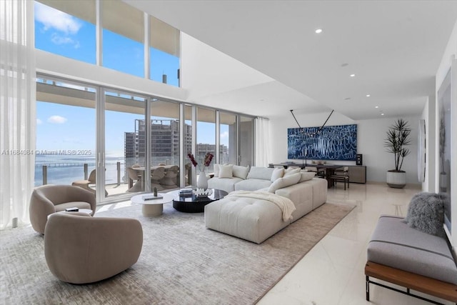 living area featuring a water view, plenty of natural light, a view of city, and recessed lighting