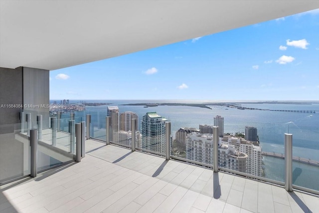 balcony featuring a water view and a city view