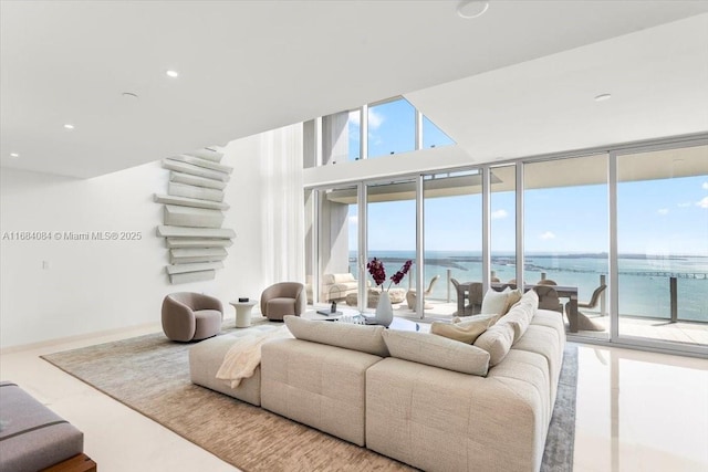 living area with a wall of windows, recessed lighting, and a water view