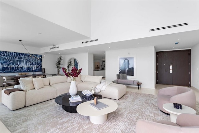 living area featuring a high ceiling, visible vents, and recessed lighting