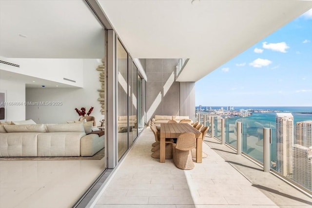 balcony featuring a water view, visible vents, and a city view