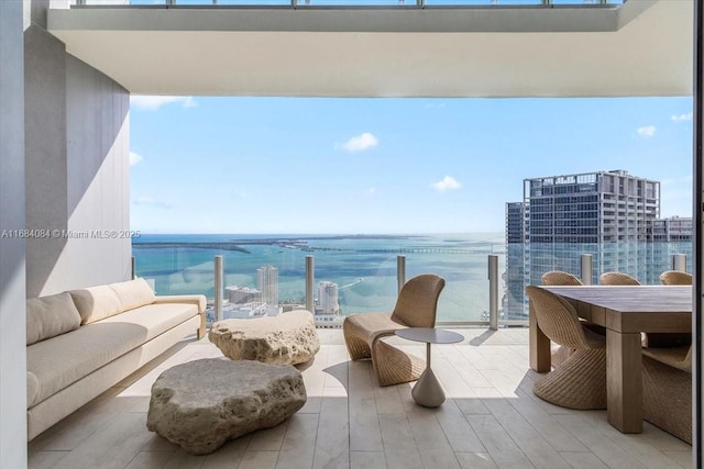 balcony featuring a water view, a city view, and an outdoor hangout area