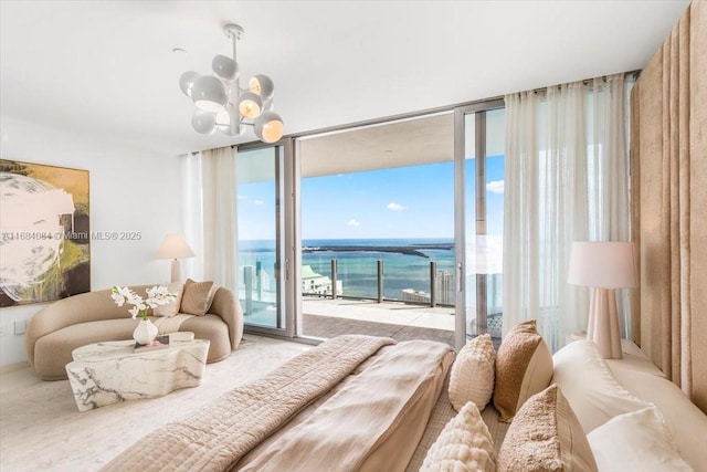 bedroom featuring a chandelier, access to outside, floor to ceiling windows, and a water view