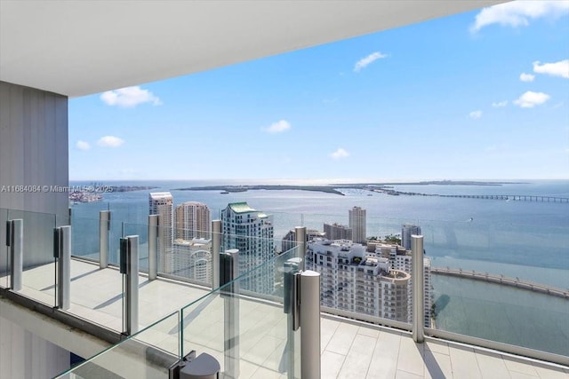 balcony featuring a water view and a city view