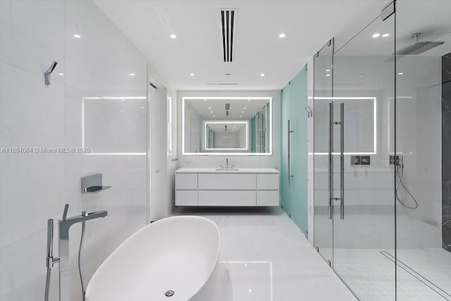 full bath featuring visible vents, a freestanding tub, a shower stall, and vanity