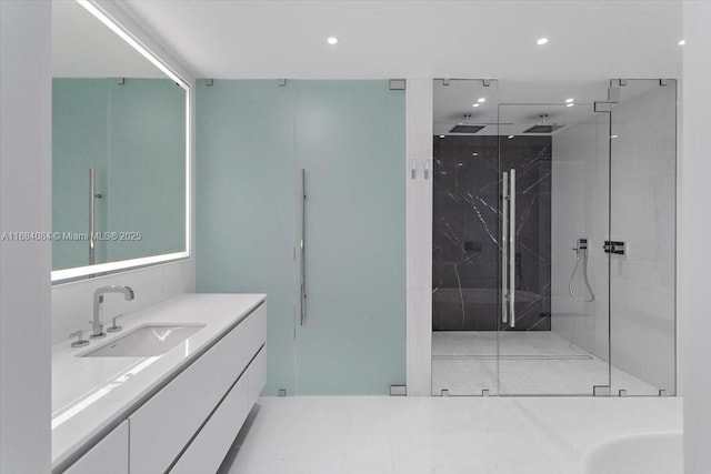 bathroom with a marble finish shower, vanity, and recessed lighting