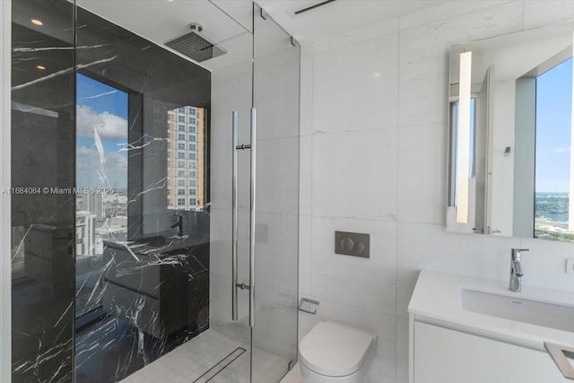 full bathroom featuring tile walls, a marble finish shower, vanity, and toilet