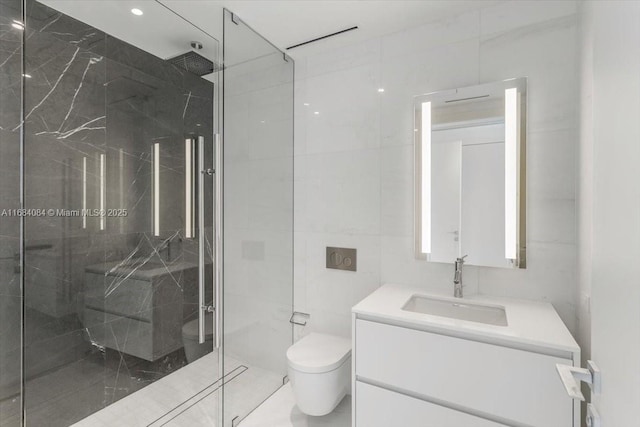 bathroom featuring tile walls, a marble finish shower, vanity, and toilet