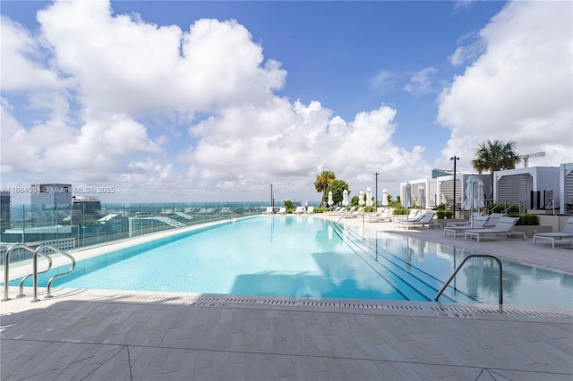 pool featuring a patio area, a city view, and fence