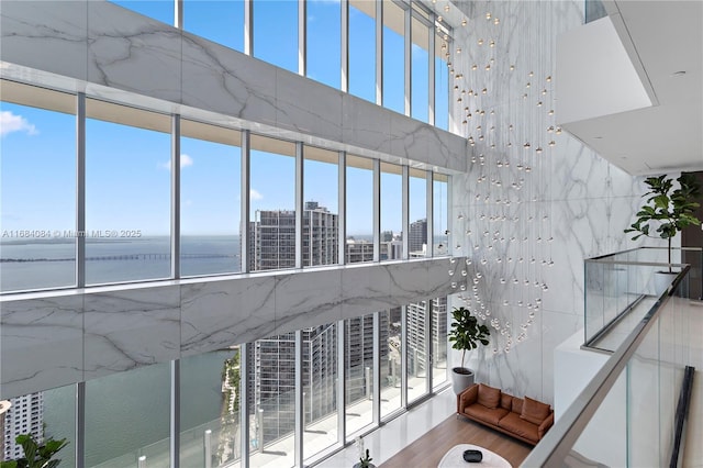 stairway with a water view, a towering ceiling, and wood finished floors