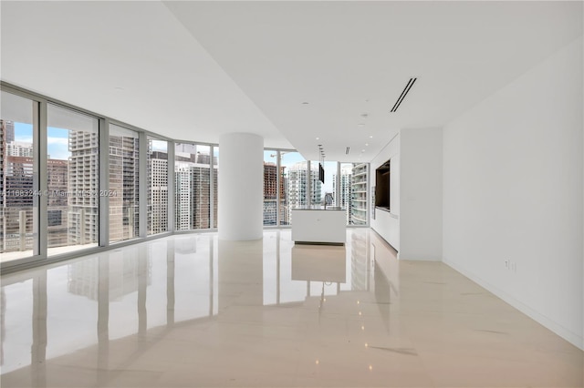 spare room featuring expansive windows and light tile patterned flooring