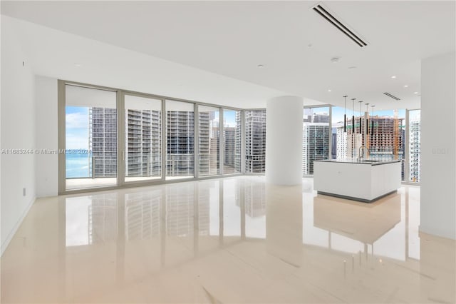 interior space with a water view, sink, and floor to ceiling windows